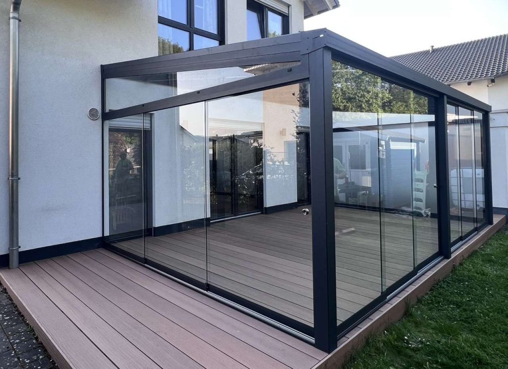 Freistehender Kaltwintergarten mit Glasschiebewänden an allen Seiten