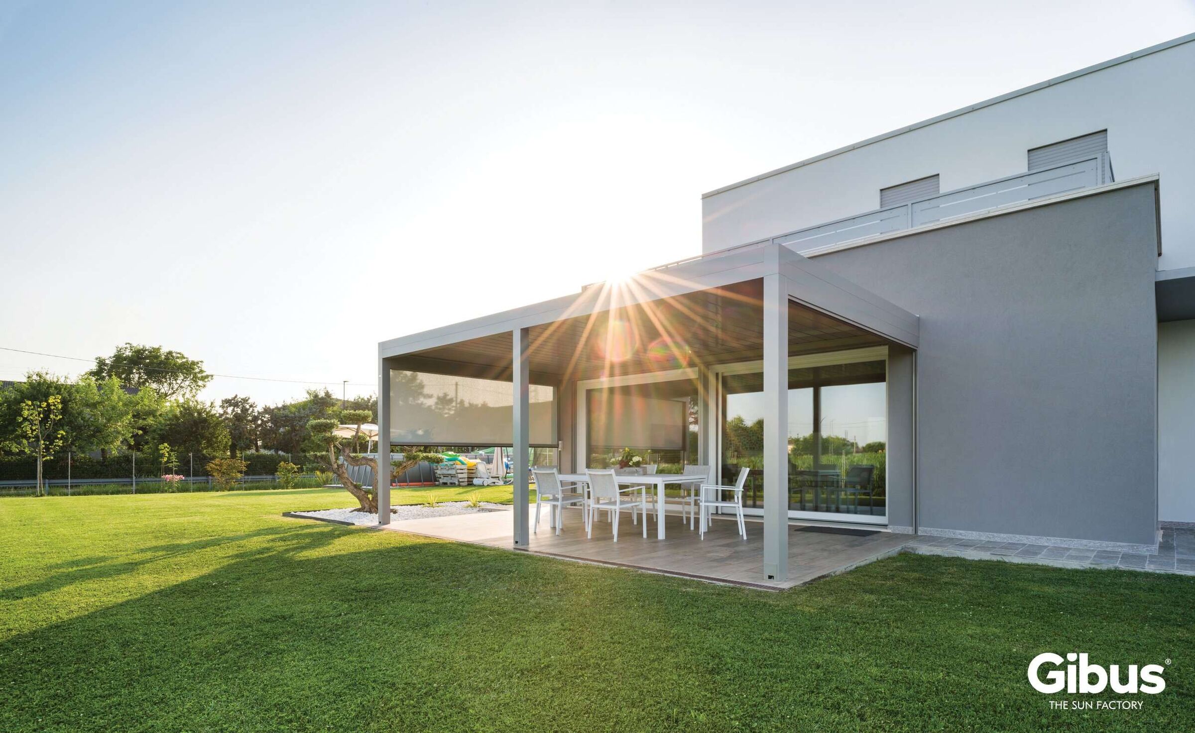 Lamellendach Gibus Joy auf einer modernen Terrasse, geöffnetes Lamellensystem für Sonnen- und Wetterschutz, hochwertige Aluminiumkonstruktion mit Zip-Screens, montiert im Garten eines Einfamilienhauses.