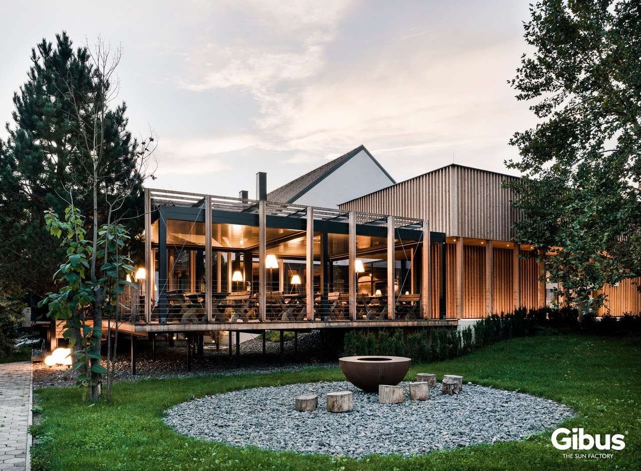 Gibus-Pergola mit wegfahrbaren Lamellen über einer Terrasse