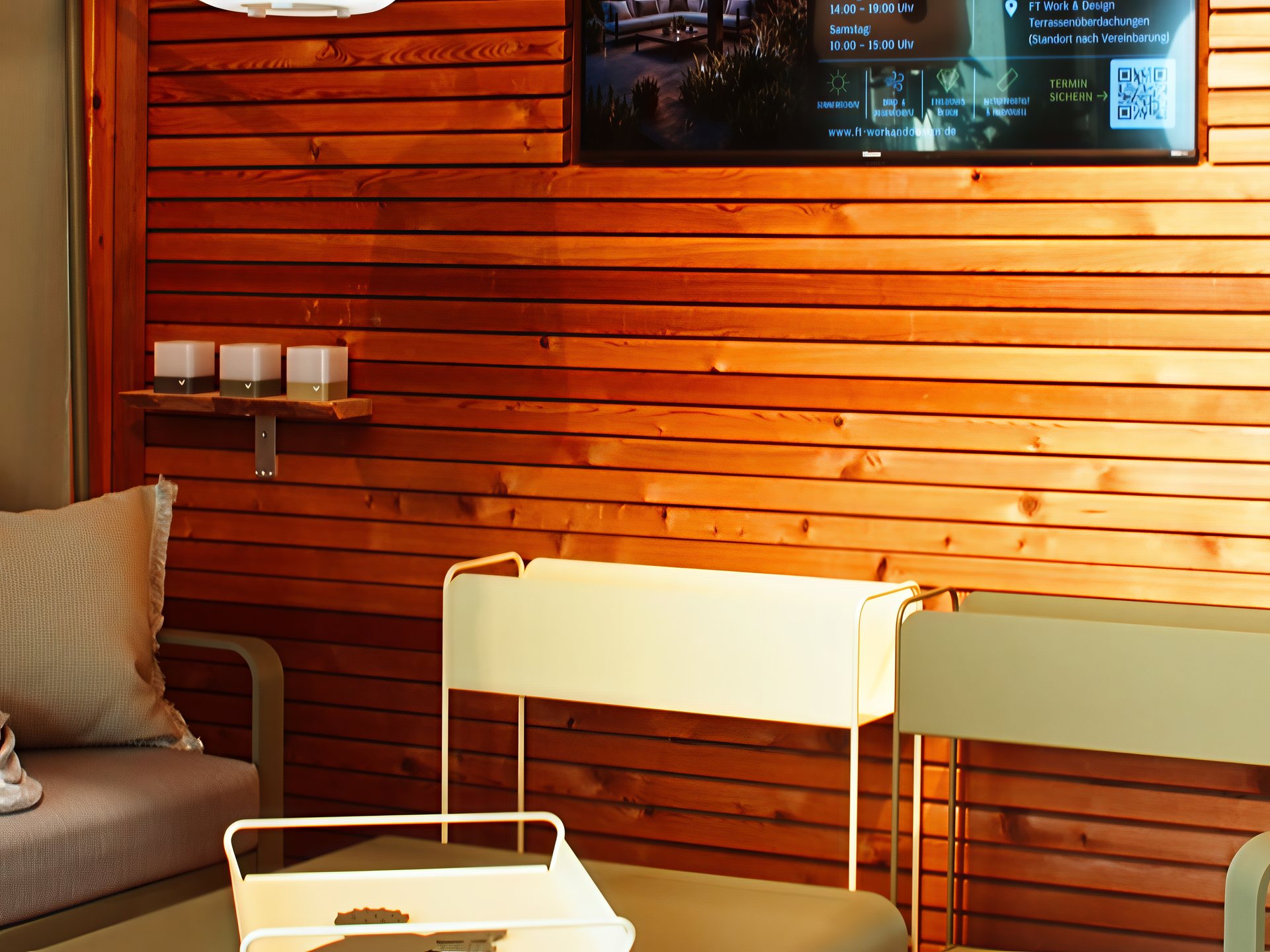 Outdoor-Lounge mit Beistelltisch vor einer Holzwand in der Ausstellung von FT Work & Design